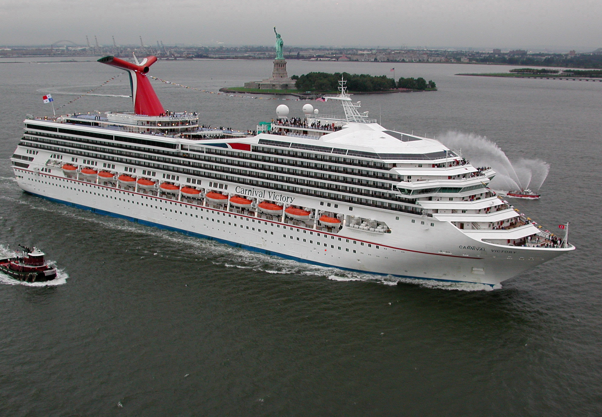 NEW YORK, N.Y. -- Carnival Cruise LinesÕ newest ship, the 2,758-passenger Carnival Victory, passes by the Statue of Liberty while arriving in New York, Monday, Aug. 14, 2000, following a trans-Atlantic crossing from the Italian shipyard where it was built. The 15th vessel in the lineÕs fleet is 893 feet long and its top deck rises 135 feet above the waterline. The vessel is to embark on a schedule of  four- and five-day cruises from New York to the Canadian Maritime Provinces on August 30 and in October is to be reposition to Miami, where it will sail alternating seven-day eastern and western Caribbean itineraries until next spring, when it will return to New York for a season of eastern Canada cruises. Photo by Andy Newman/CCL